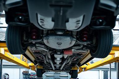 リフトアップされた車両の下部メンテナンス